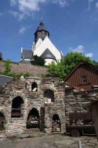 un antiguo edificio de piedra con una torre de reloj en el fondo en Dreibettzimmer-in-Wiesa, en Thermalbad Wiesenbad