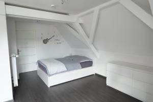 a white room with a bed in a attic at BITO CAMPUS in Meisenheim