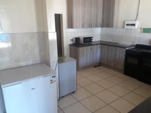 a kitchen with a white refrigerator and a stove at Coolden guesthouse in Vanderbijlpark