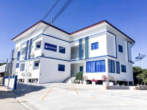 a white house with blue windows at Blue House in Ang Thong
