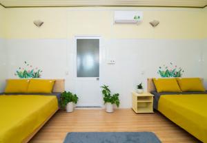 a living room with two beds and plants at Pun corner homestay in Con Dao