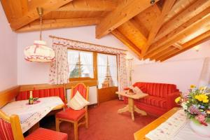 a living room with red chairs and a red couch at Landhaus Mayer in Oberstdorf