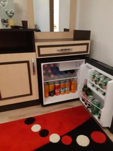 una pequeña cocina con nevera abierta y alfombra roja en Florin Apartament, en Sighişoara