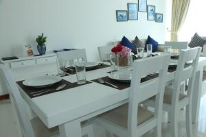 a white dining room table with white chairs and a white table and chairsearcher at BEACH HAVEN NILAVELI in Nilaveli