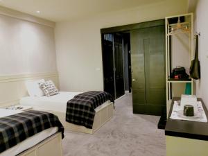 a hotel room with two beds and a green closet at Chomm House in Bangkok