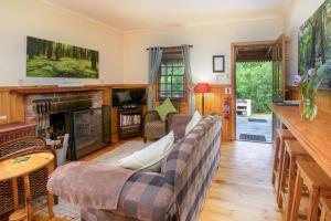 uma sala de estar com um sofá e uma lareira em Forest Edge em Rheenendal