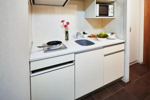 a small kitchen with a sink and a refrigerator at Citadines Kyoto Karasuma-Gojo in Kyoto
