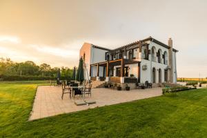 a house with a patio with tables and chairs at Villa Ciao - Adults Only in Corbu