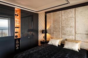 een slaapkamer met een groot zwart bed en een raam bij Golden Eye Apartament Seaside Park in Kołobrzeg