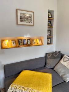 uma sala de estar com um sofá cinzento com um cobertor amarelo em Appartement Odyssée - Welkeys em Megève
