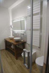 a bathroom with two sinks and a mirror and a toilet at Montis Country & Charme in San Massimo