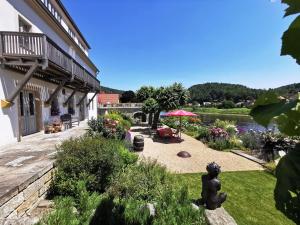 einen Garten vor einem Gebäude neben einem Fluss in der Unterkunft Elbterrasse Wehlen in Stadt Wehlen