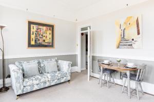 een woonkamer met een bank en een tafel bij Warwick Victorian Apartment in Warwick