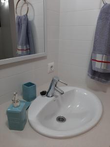 a white sink in a bathroom with a mirror at PRECIOSO DUPLEX EN CALA SANTANDRIA CON PISCINA Y WIFI in Son Carrio +37 photos