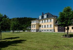 a large yellow house with a large yard at Residenz Itterbach in Willingen