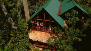 un grupo de personas sentadas en una terraza en una casa del árbol en Jungle Face Inn, en Ella