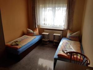 a small room with two beds and a window at Hotel Arkona in Genthin