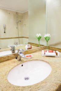 Hotel Royal Plaza في مدينة إيبيزا: منضدة الحمام مع حوض أبيض ومرآة