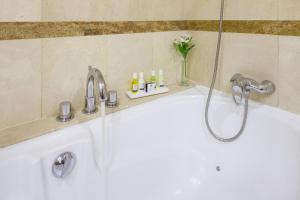 a white bath tub sitting next to a white sink at Hotel Royal Plaza in Ibiza Town