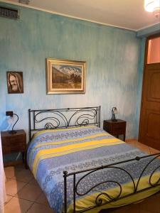 1 dormitorio con 1 cama con pared azul en Villa Assunta en Premeno