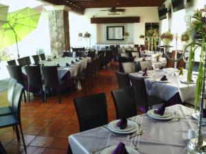 a dining room with tables and chairs with white tablecloths at Hotel Villa Mexicana Golf & Equestrian Resort in Villa del Pueblito +21 photos