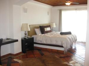 1 dormitorio con cama y ventana grande en Hotel Villa Mexicana Golf & Equestrian Resort, en Villa del Pueblito