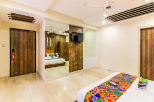 a bedroom with a bed and a bathroom at FabHotel Sahar Garden Marol in Mumbai
