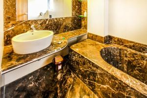 a bathroom with a sink and a mirror at FabHotel Sahar Garden Marol in Mumbai