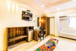 a room with a bed and a kitchen with a counter at FabHotel Sahar Garden Marol in Mumbai
