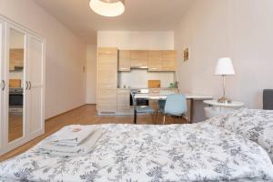 a bedroom with a bed and a kitchen with a table at Premium Aufenthalt l LF23 in Vienna