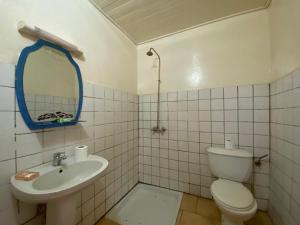 a bathroom with a toilet and a sink and a mirror at Hotel Levy's in Bangui