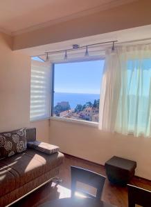- un salon avec un canapé et une grande fenêtre dans l'établissement Apartment Kosović, à Dubrovnik