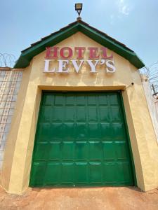 a large green garage door with a sign on top at Hotel Levy's in Bangui