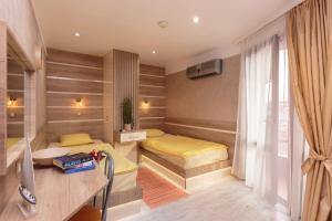 a small room with two beds and a desk at Apart & Rooms Fotinov in Burgas City