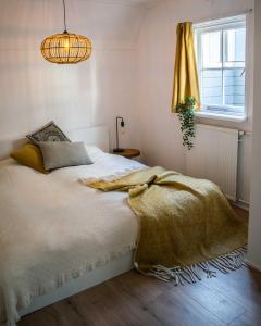 um quarto com uma cama com um cobertor e uma janela em Jantjes lief appartement em Zwolle