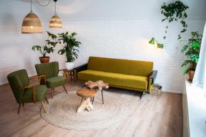 a living room with a green couch and chairs at Jantjes lief appartement in Zwolle