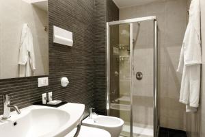 a bathroom with a shower, sink, and mirror at Hotel Palazzo Brunaccini in Palermo