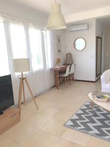 sala de estar con TV, mesa y sillas en CALA BLANCA-TORRE BELLVER, en Cala Blanca