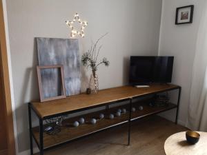 einen Tisch mit einem Fernseher und einem Bild darauf in der Unterkunft Ferienwohnung Schreckenbach in Sankt Egidien