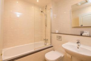a bathroom with a shower and a toilet and a sink at Glen-Yr-Afon House Hotel in Usk