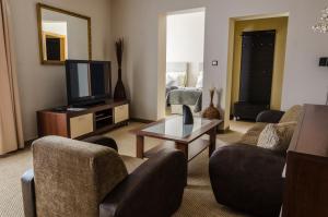 a living room with a tv and chairs and a table at Hotel Rokoko in Košice