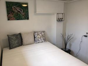 een kleine slaapkamer met een bed met witte lakens bij Vettebar Guesthouse in Gislinge