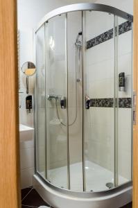 a shower with a glass door in a bathroom at Hotel Rokoko in Košice