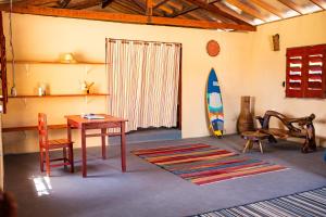 a room with a table and a surfboard in it at Beach House- KiteAliCori in Ponta do Anel