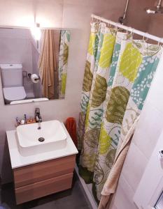 uma casa de banho com um lavatório e uma cortina de chuveiro em Apartamento acogedor a 3 minutos de la playa em Blanes