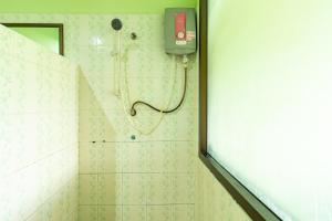 a bathroom with a shower with a phone on the wall at Khum Suk Resort in Songkhla
