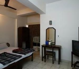 una camera con letto, tavolo e specchio di Baseraa Hotel a Rishikesh