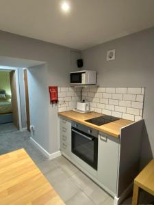 a small kitchen with a stove and a microwave at garden view apartment in Bangor