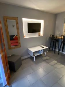 een woonkamer met een tafel en een tv aan de muur bij garden view apartment in Bangor