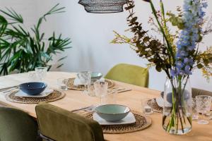 uma mesa com pratos e tigelas e um vaso com flores em Jantjes lief appartement em Zwolle